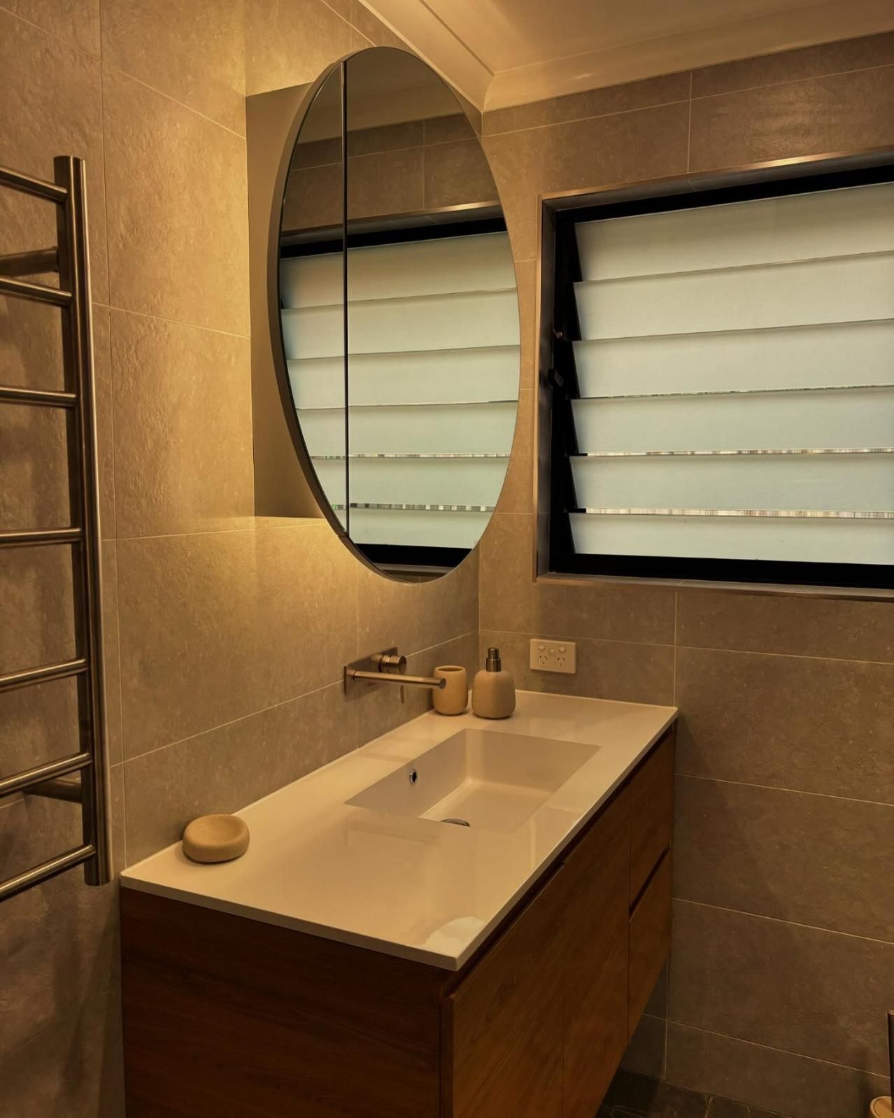 A Bathroom With A Sink And A Round Mirror — Oceanforce Plumbing In Blacksmiths, NSW