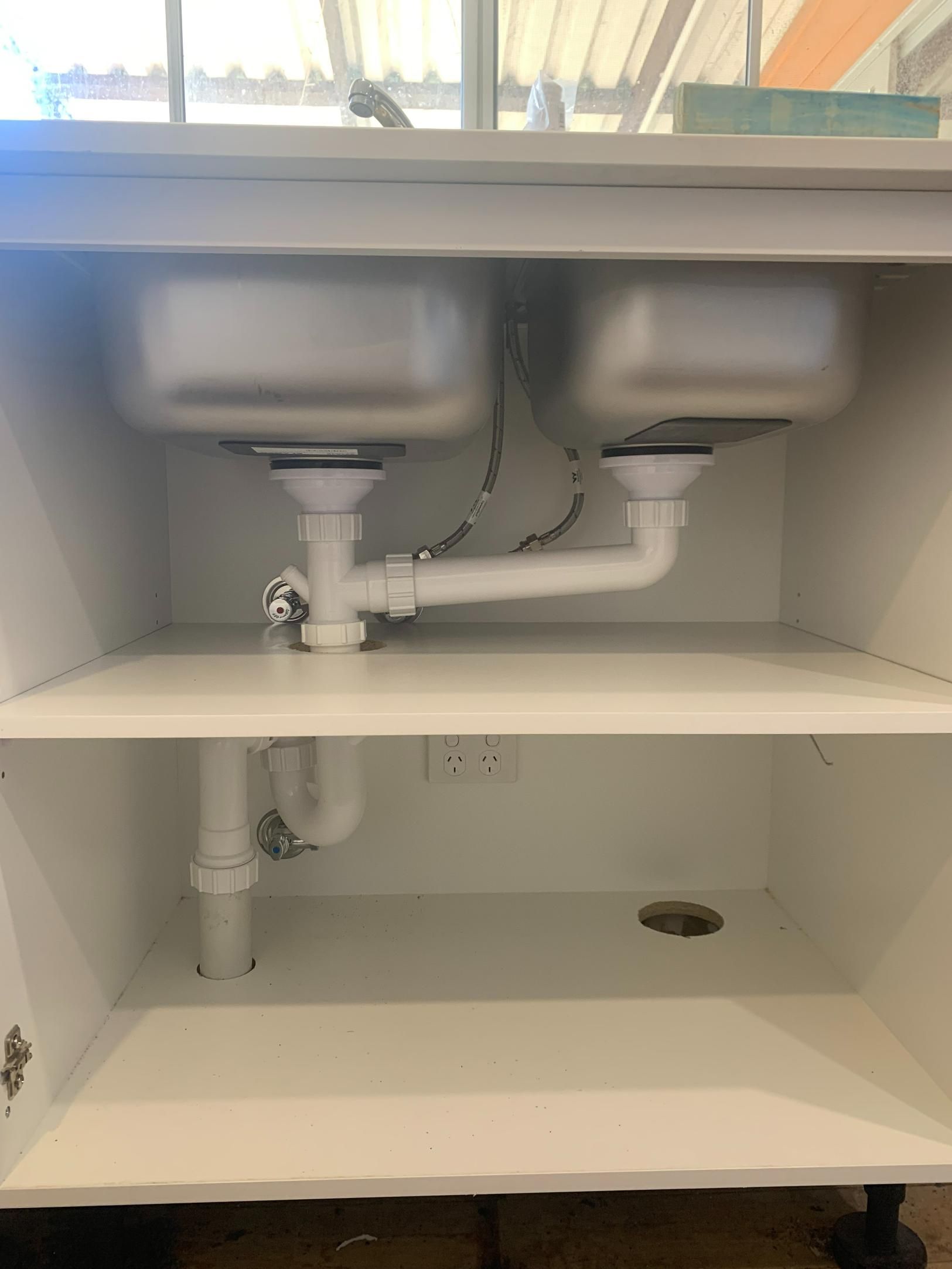 A Kitchen Sink Is Sitting Under A Cabinet With Two Sinks — Oceanforce Plumbing In Blacksmiths, NSW