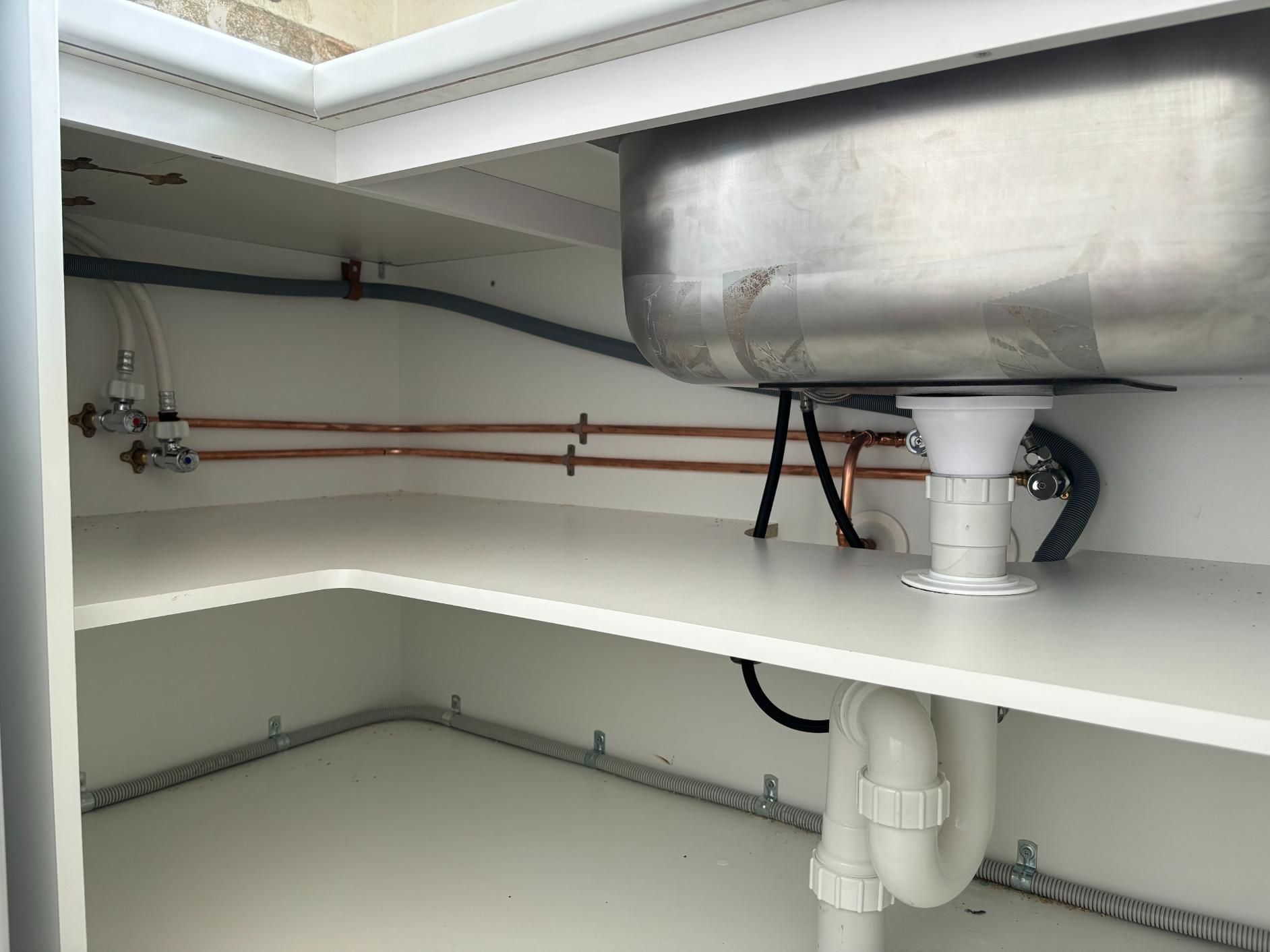 A Stainless Steel Sink Is Underneath A White Cabinet — Oceanforce Plumbing In Blacksmiths, NSW