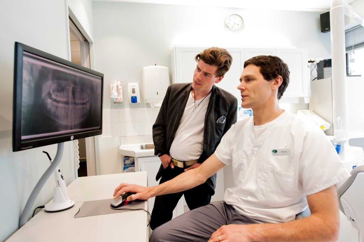 patient and dentist checking dental x-rays