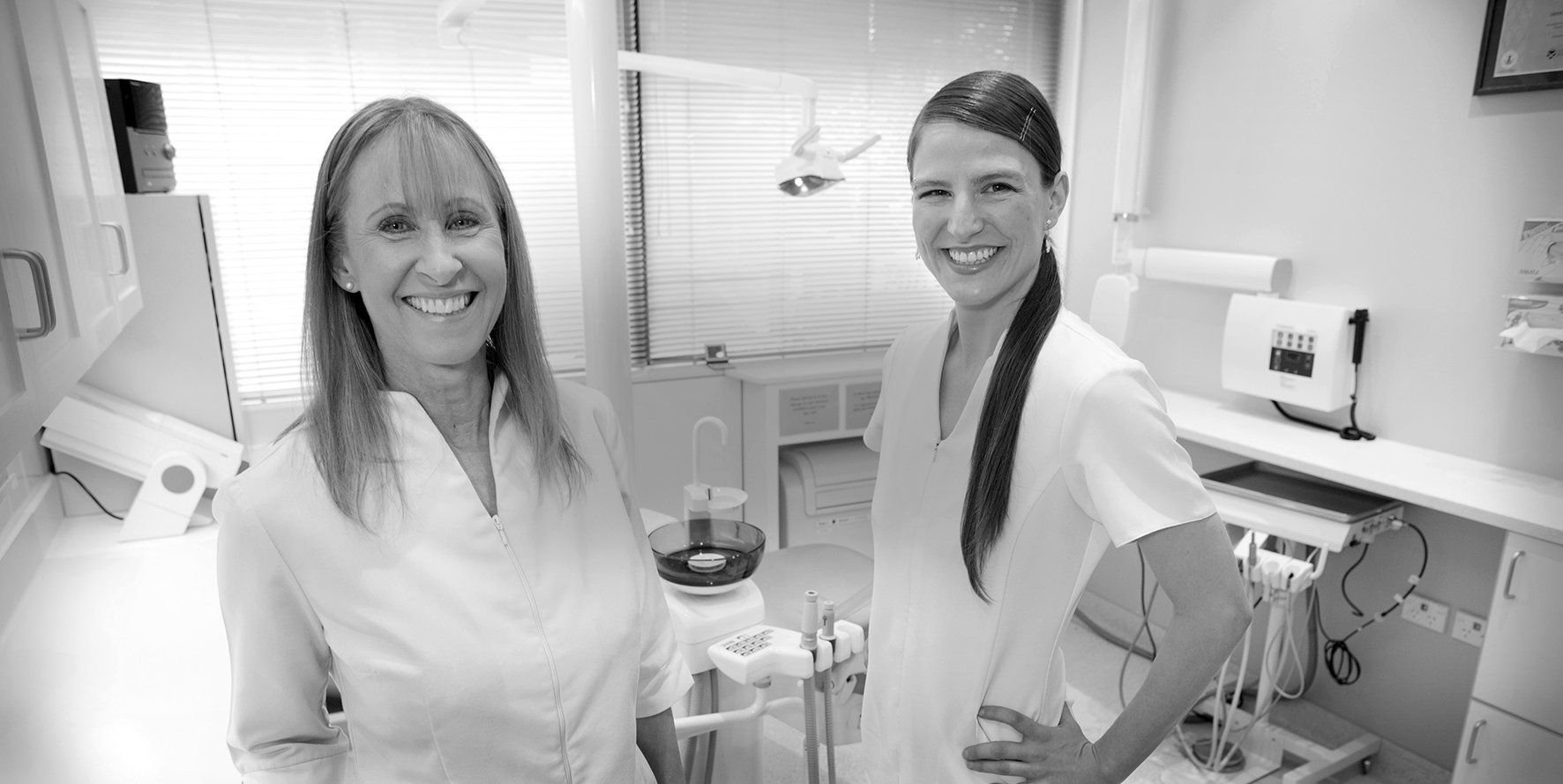 Two women are standing next to each other in a dental office.