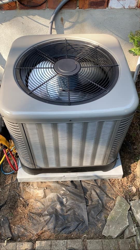 A large air conditioner is sitting on top of a concrete platform.