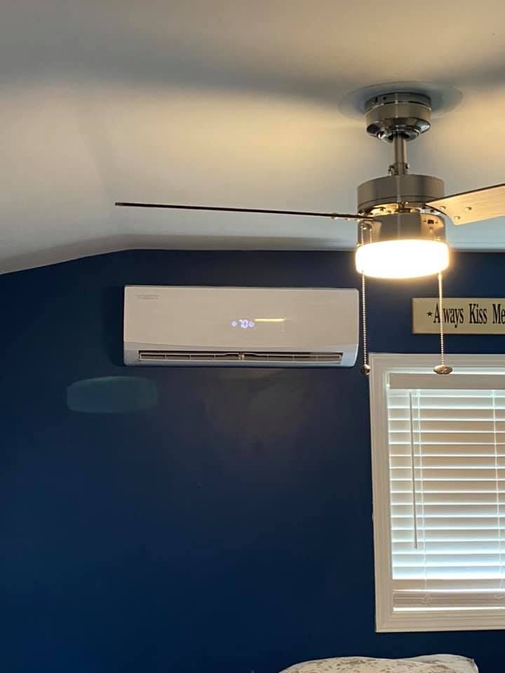 A ceiling fan is hanging from the ceiling in a bedroom next to a window.
