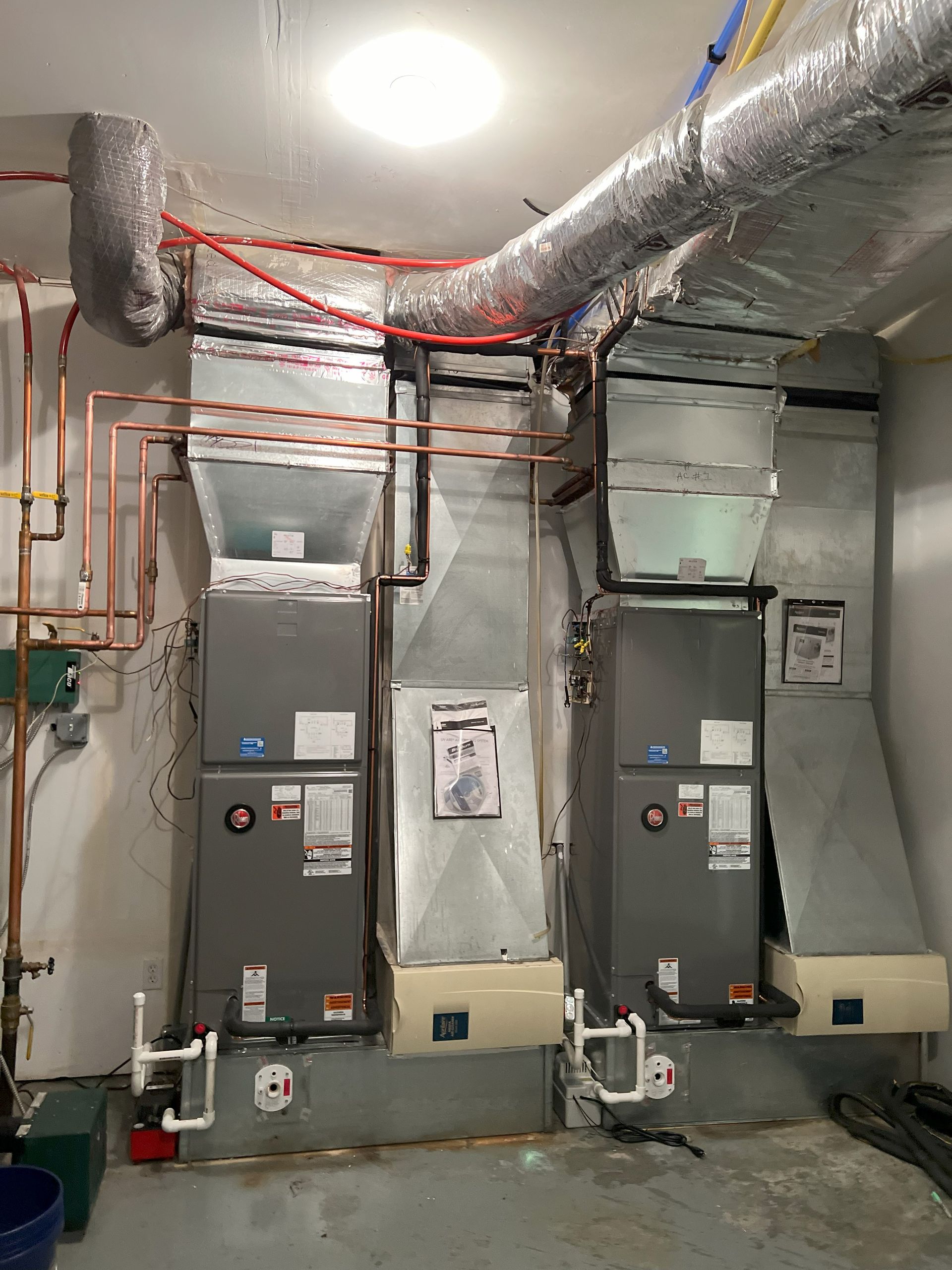 Three air conditioners are sitting next to each other in a room.