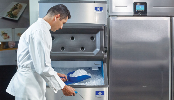 A man is scooping ice out of an ice machine.