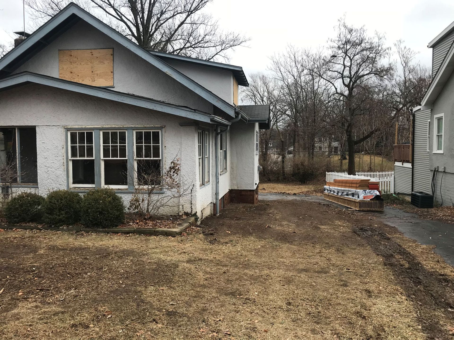 Interior of a wooden house under construction, showing framing, windows, and exposed beams.