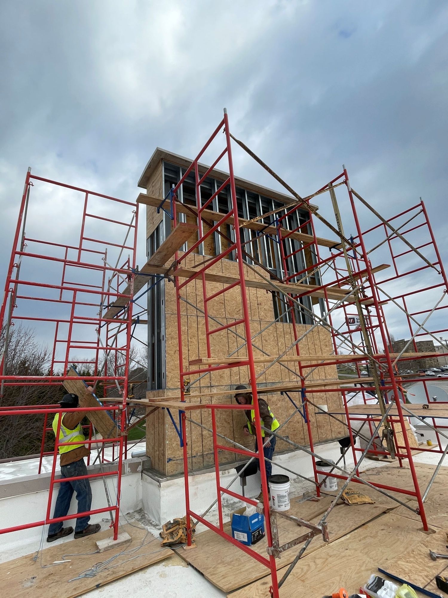 Wooden frame of a house under construction; sunlight streams through the open structure.