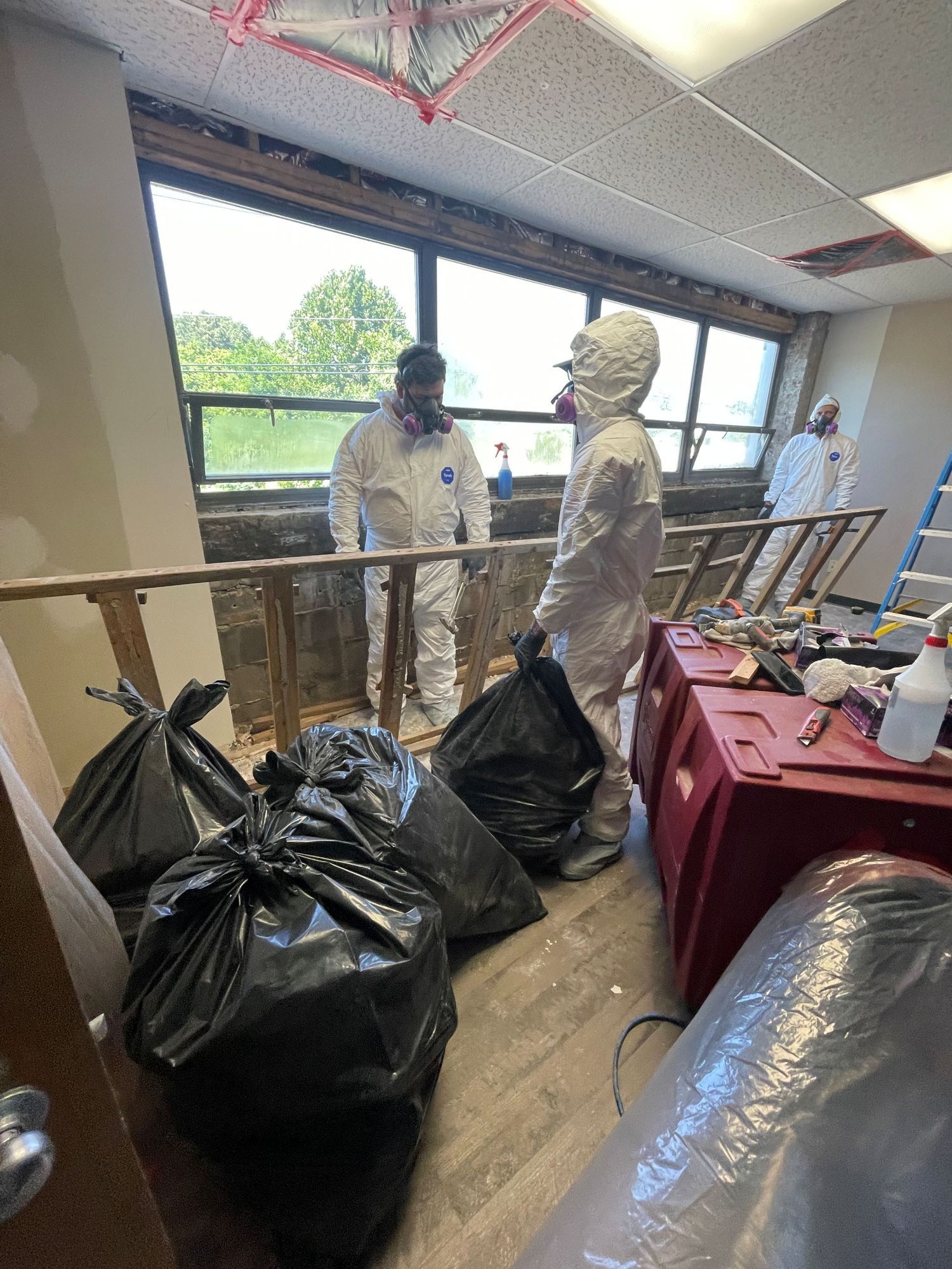 Interior of a wooden house under construction, showing framing, windows, and exposed beams.