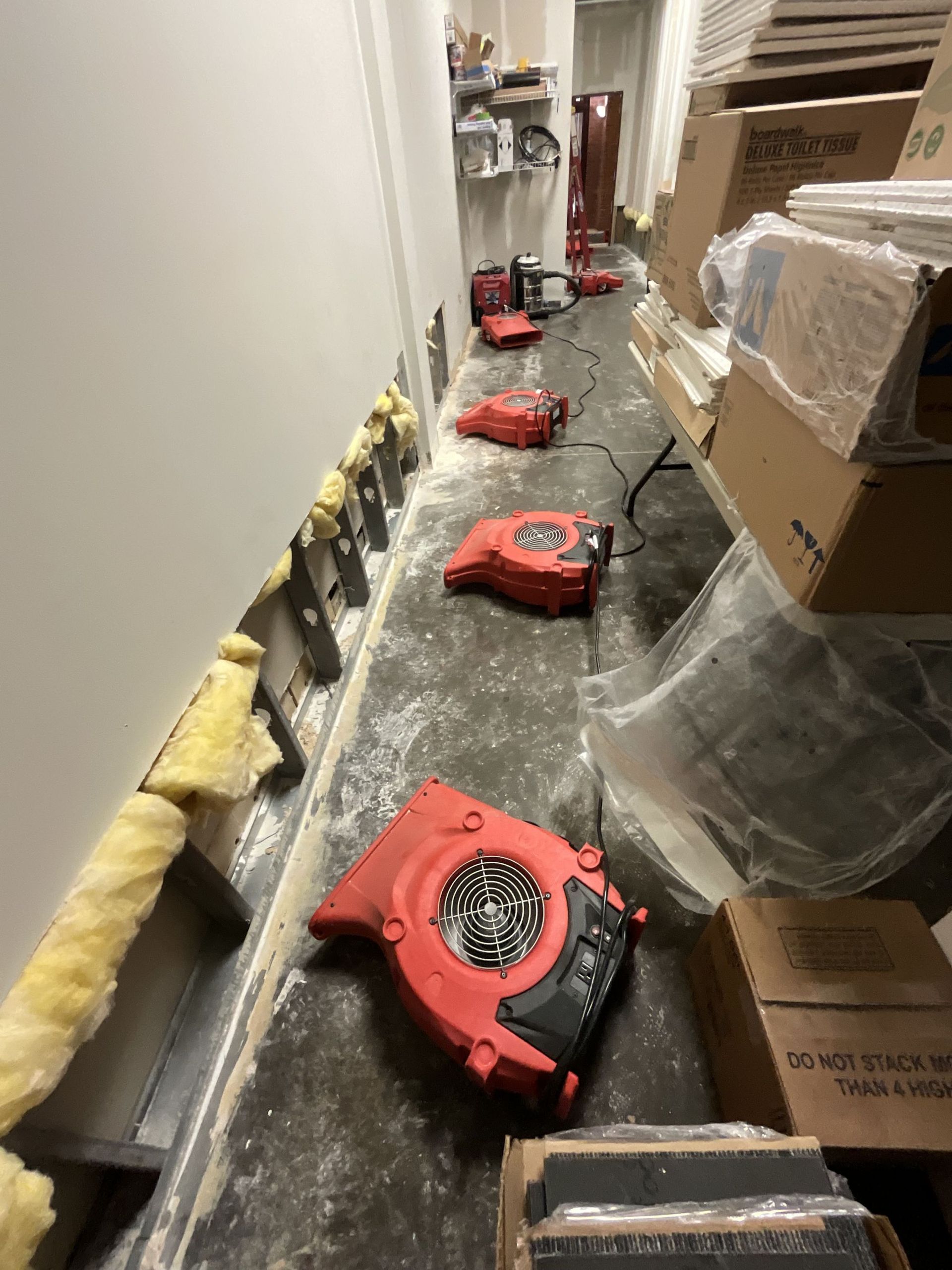 An upscale, dimly lit restaurant interior with tables, bar seating, dark carpets, and decorative globe chandeliers.