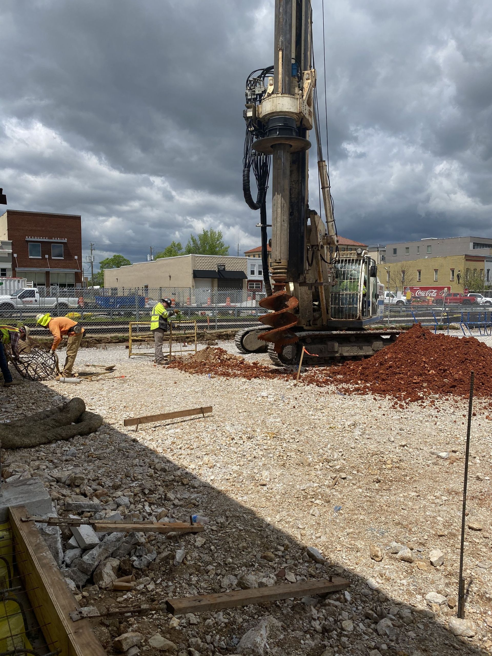 Staircase in a house under construction; drywall, wooden stairs, black metal railings.