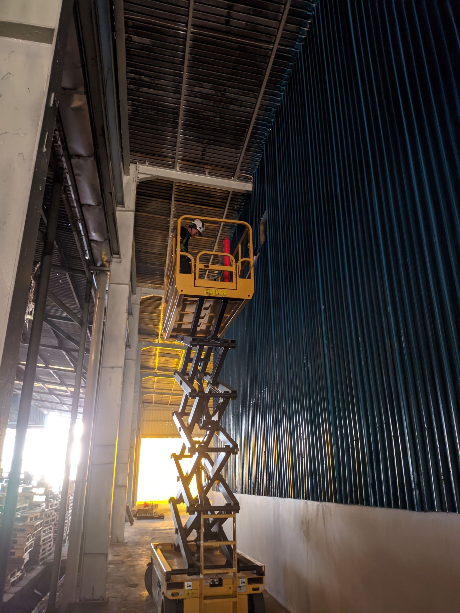 Interior of a wooden house under construction, showing framing, windows, and exposed beams.