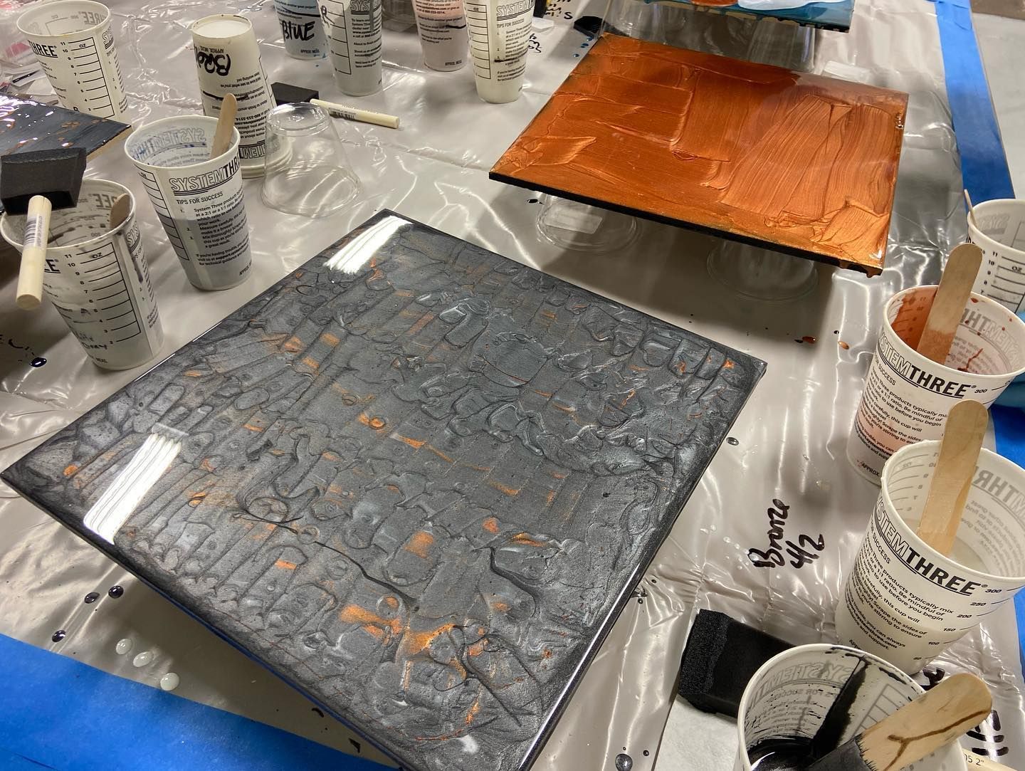 A table with a lot of cups and brushes on it.