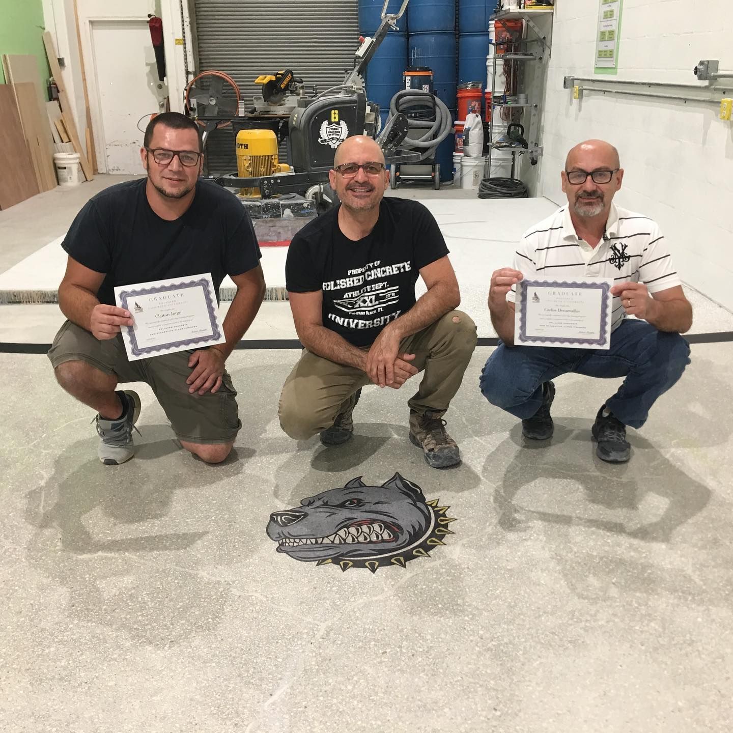 Three men are posing for a picture while holding certificates