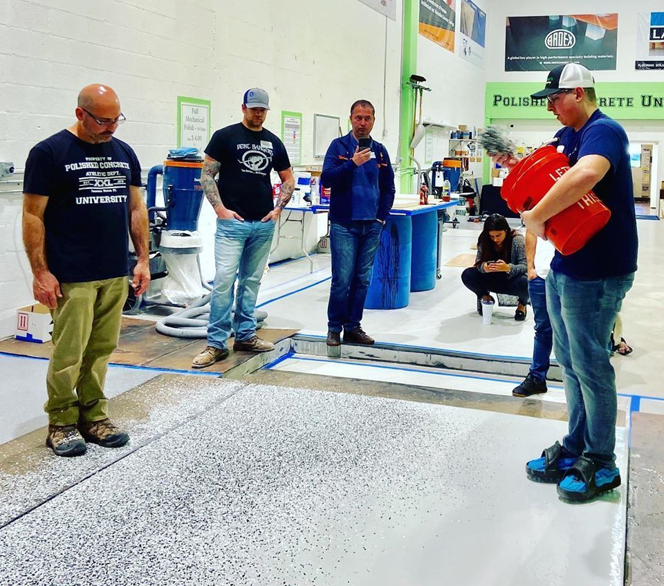 A group of men are standing in a room with a sign that says polish