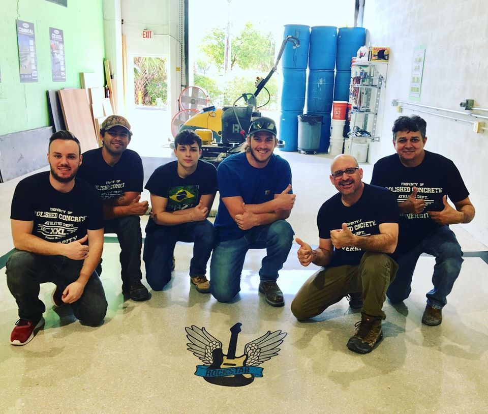 A group of men are posing for a picture and one of them is wearing a t-shirt that says video privacy