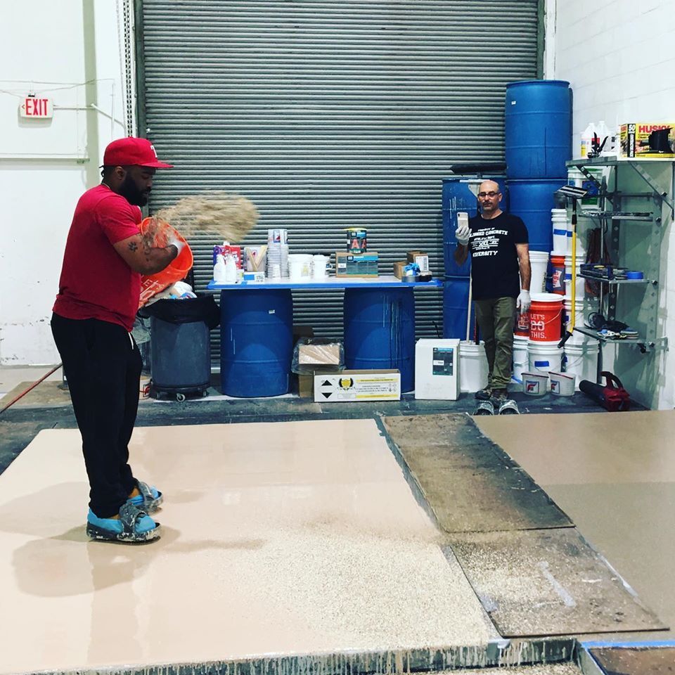 A man in a red shirt is holding a frisbee in a warehouse