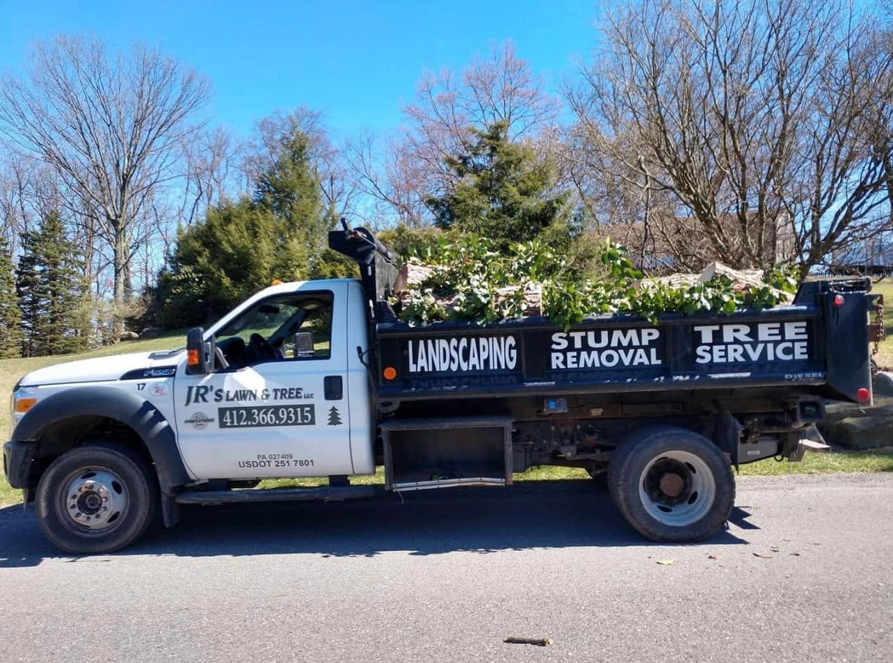 a landscaping truck is parked on the side of the road