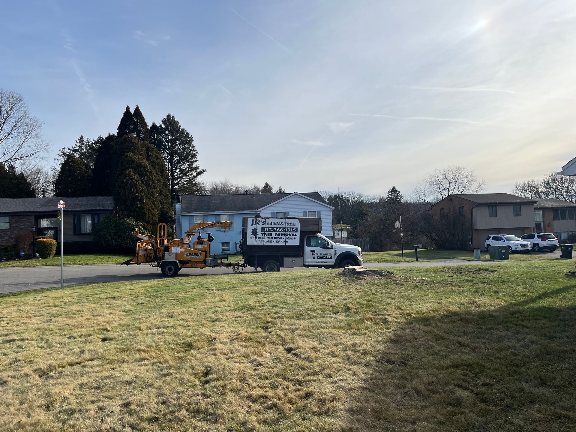 a white truck is parked in a grassy field in front of a house .