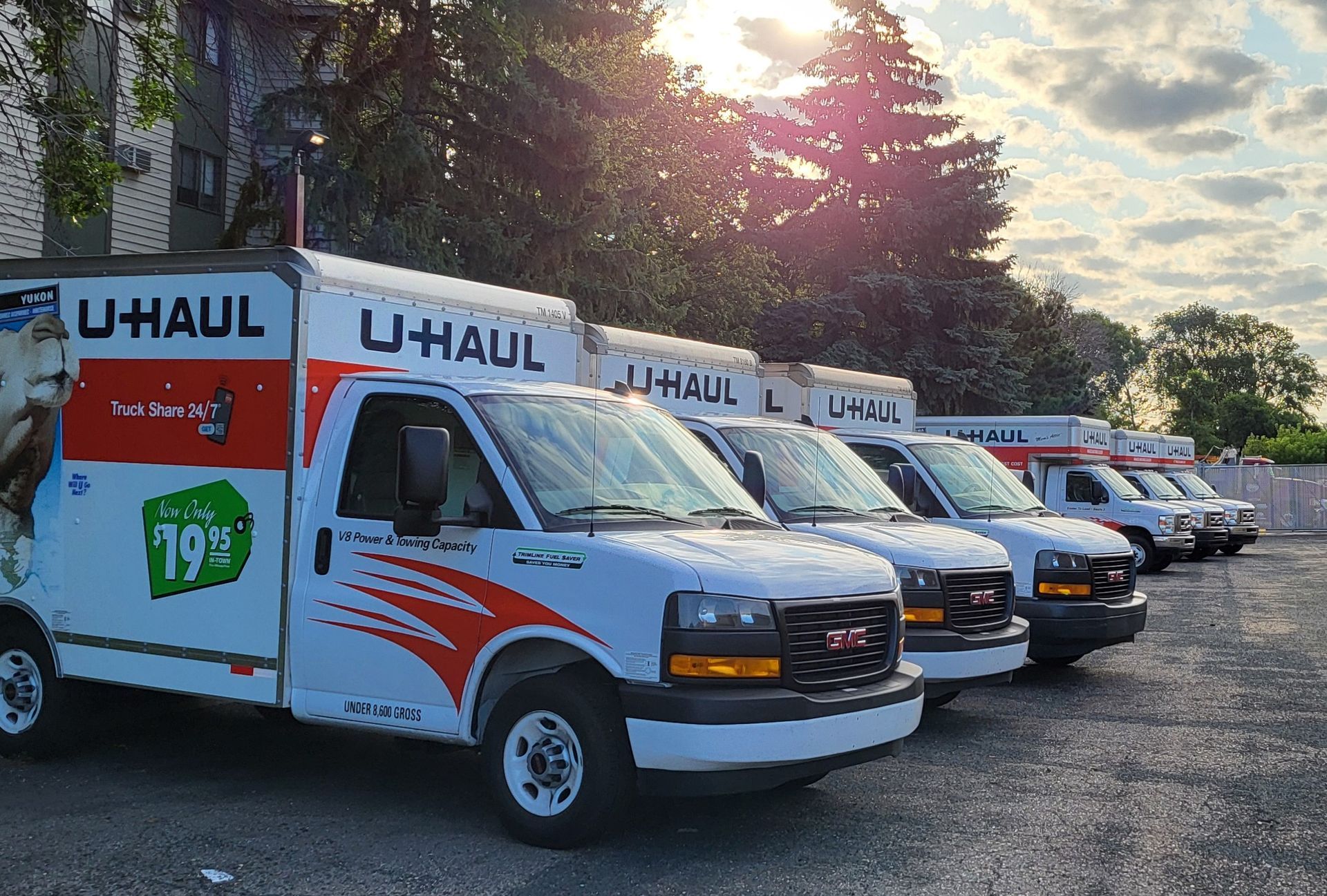 Two white delivery trucks are parked next to each other on the side of the road.