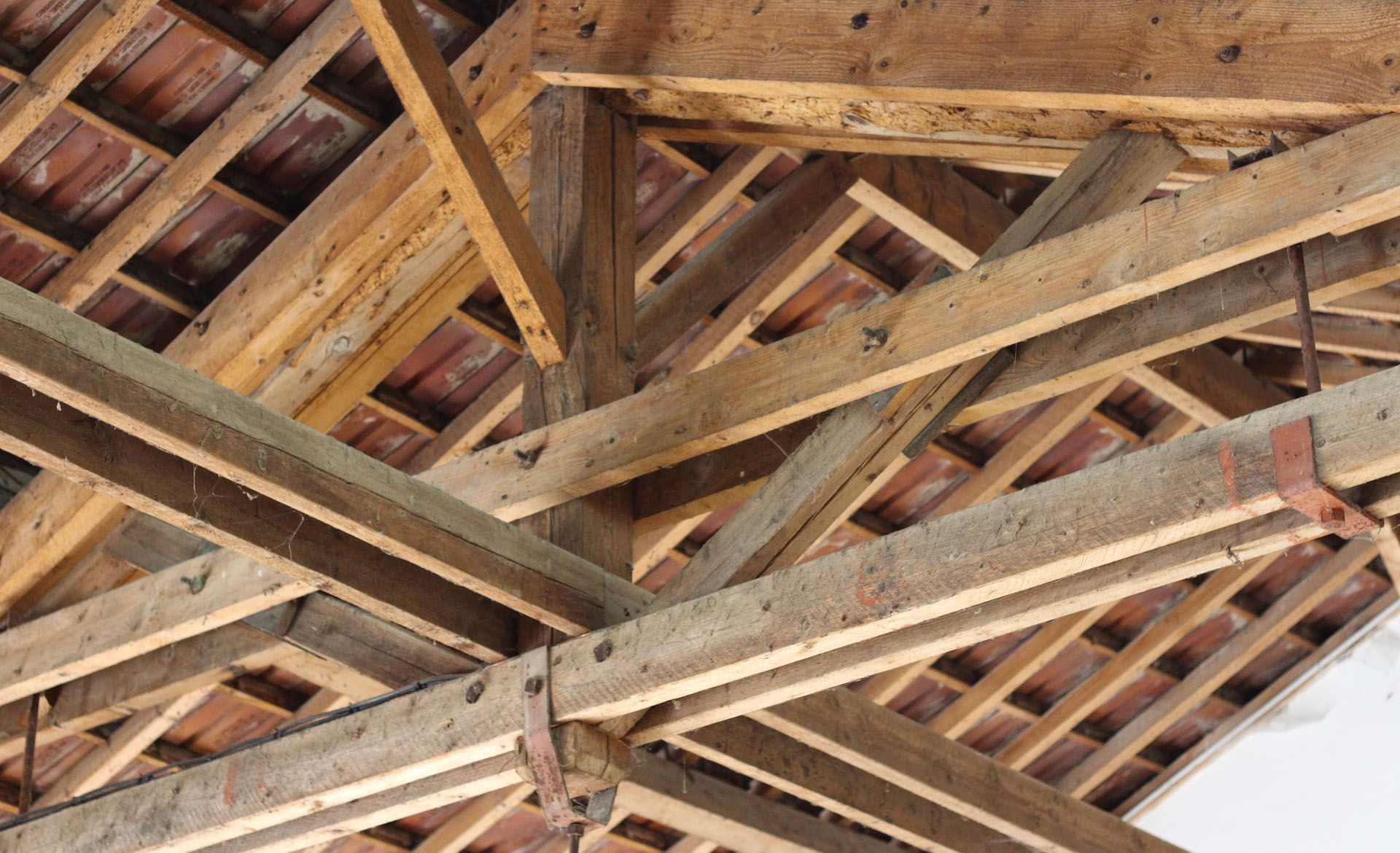 Charpente de toit en bois avec poutres et chevrons imbriqués.