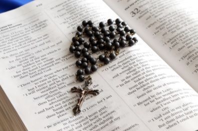 A cluster of dark grapes resting on an open book page with text visible around them