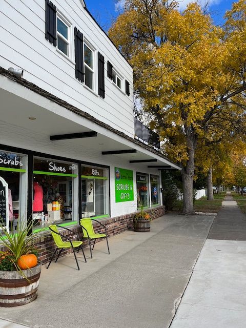 A white building with a green sign that says sunset