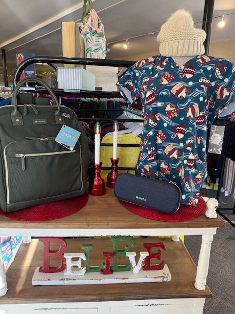 A green shirt and shorts are sitting on a carpet next to a painting of a tree.