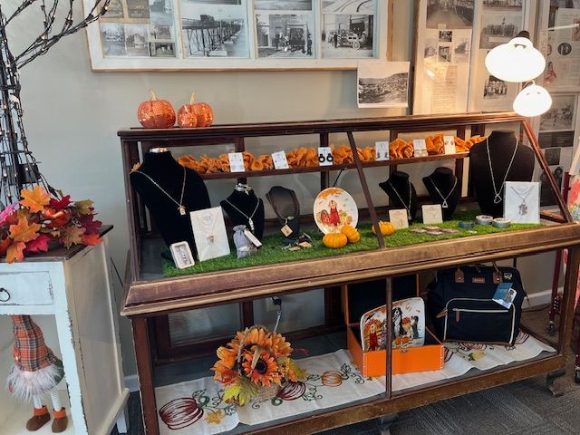 A display case filled with jewelry and pumpkins in a store