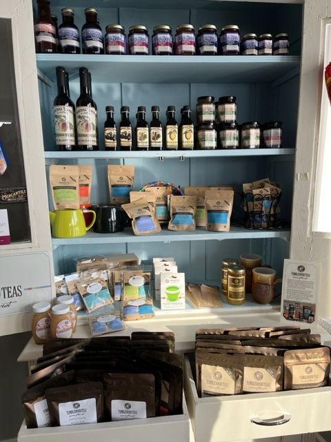 A shelf filled with bottles and bags of tea