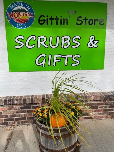 A green sign that says scrubs and gifts on it