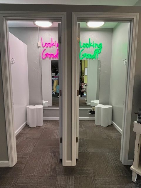A room with a neon sign that says looking good