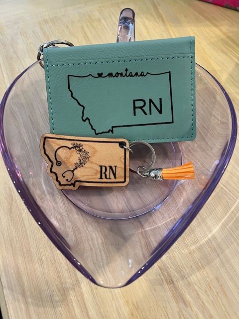 A montana wallet and a keychain are sitting on a heart shaped bowl