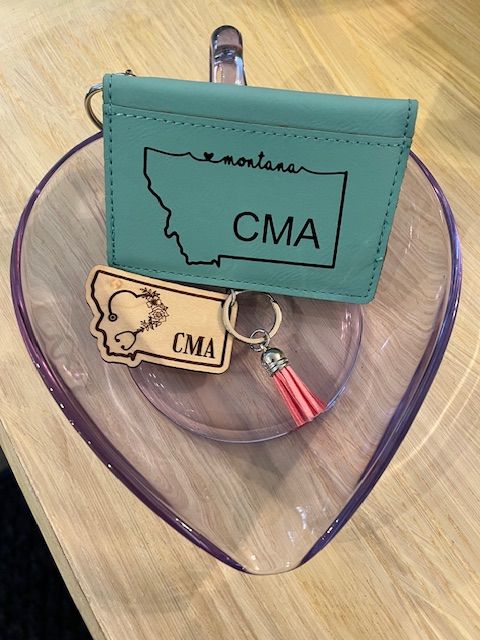 A montana wallet and a keychain are on a heart shaped tray