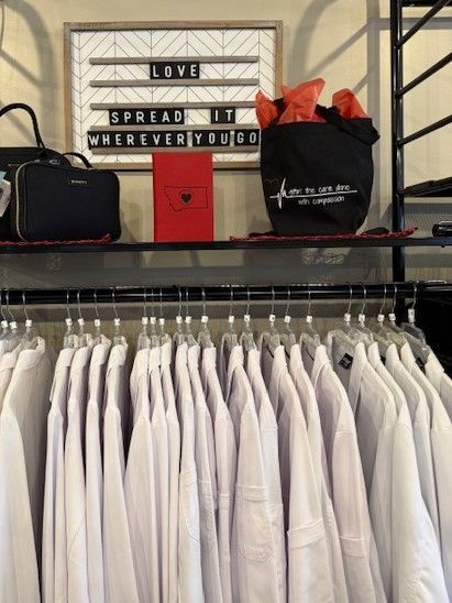A green shirt and shorts are sitting on a carpet next to a painting of a tree.