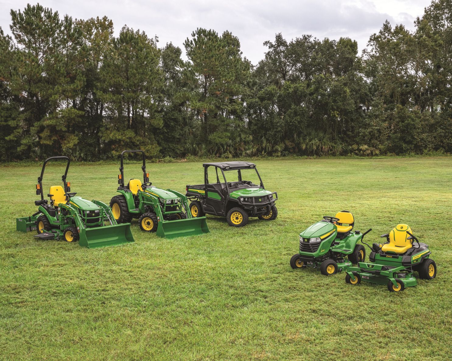 John Deere compact tractors, UTVs, and mowers in a line