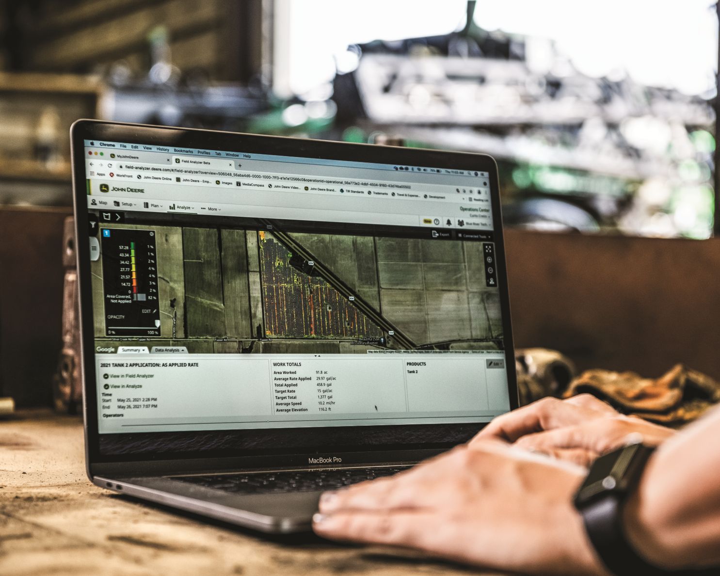 caucasian male hands on a laptop keyboard viewing his John Deere Operations Center account dashboard