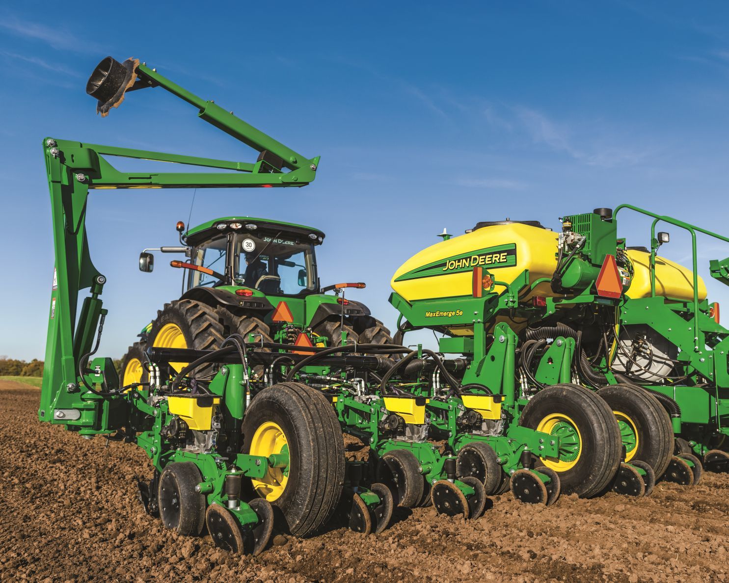Close-up of a John Deere tractor and planter in an empty field.