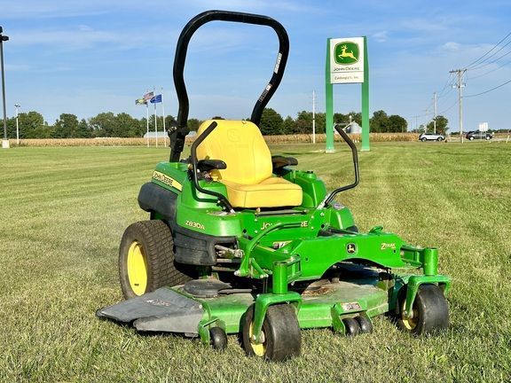 photo of a zero-turn mower in a field in front of the Castongia Tractor John Deere sign.