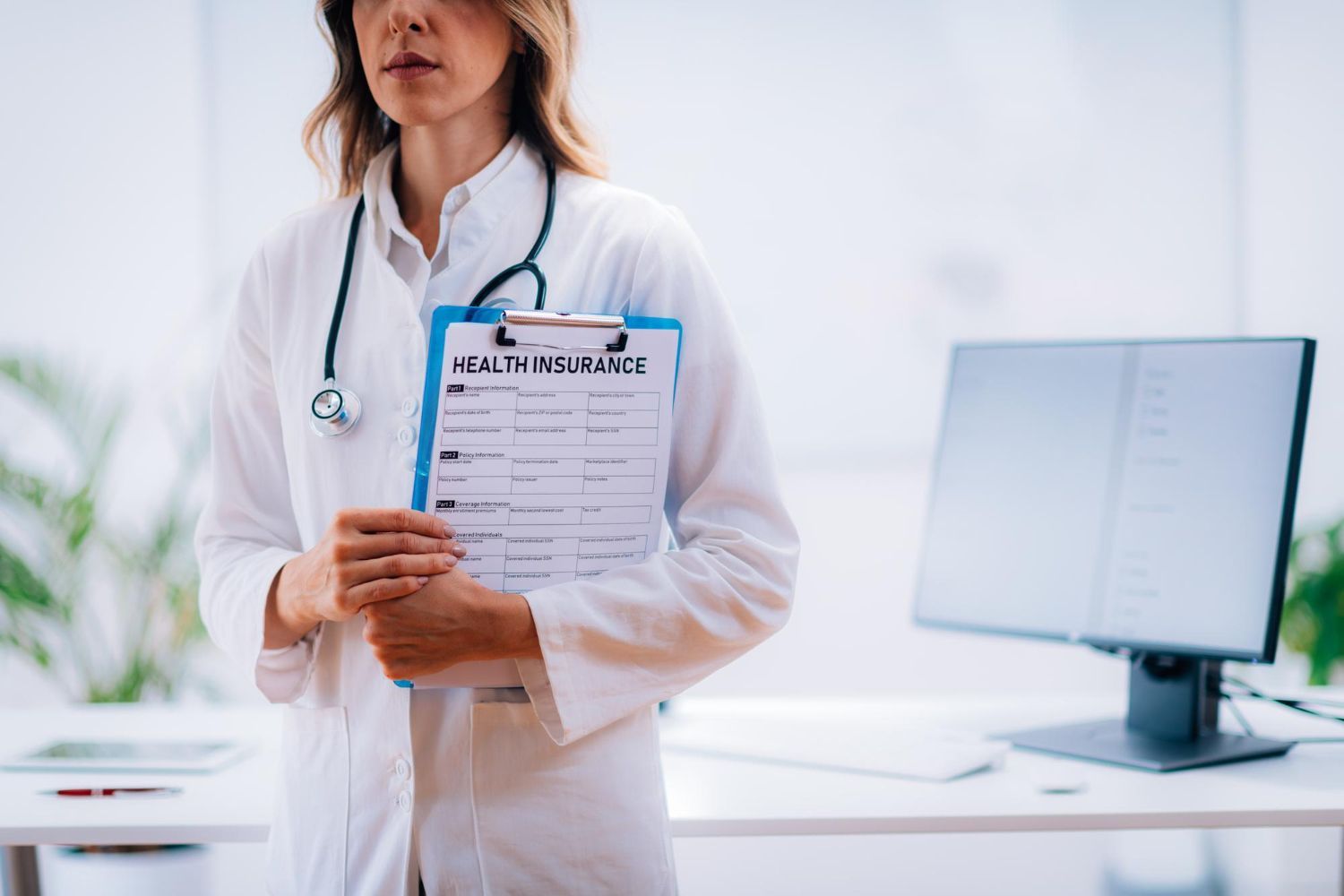 Doctor in white coat, stethoscope, holding 
