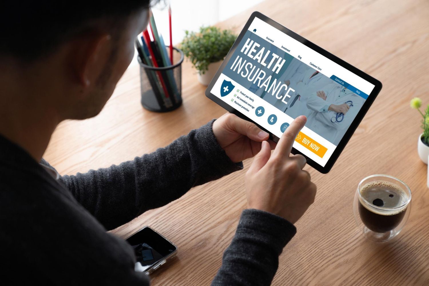 Person looking at a tablet displaying a health insurance website.