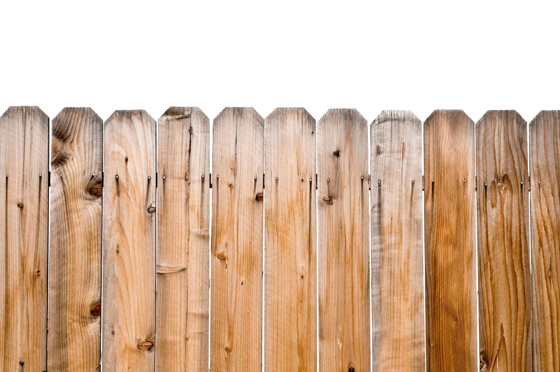 A wooden fence is sitting on top of a lush green lawn in front of a house.