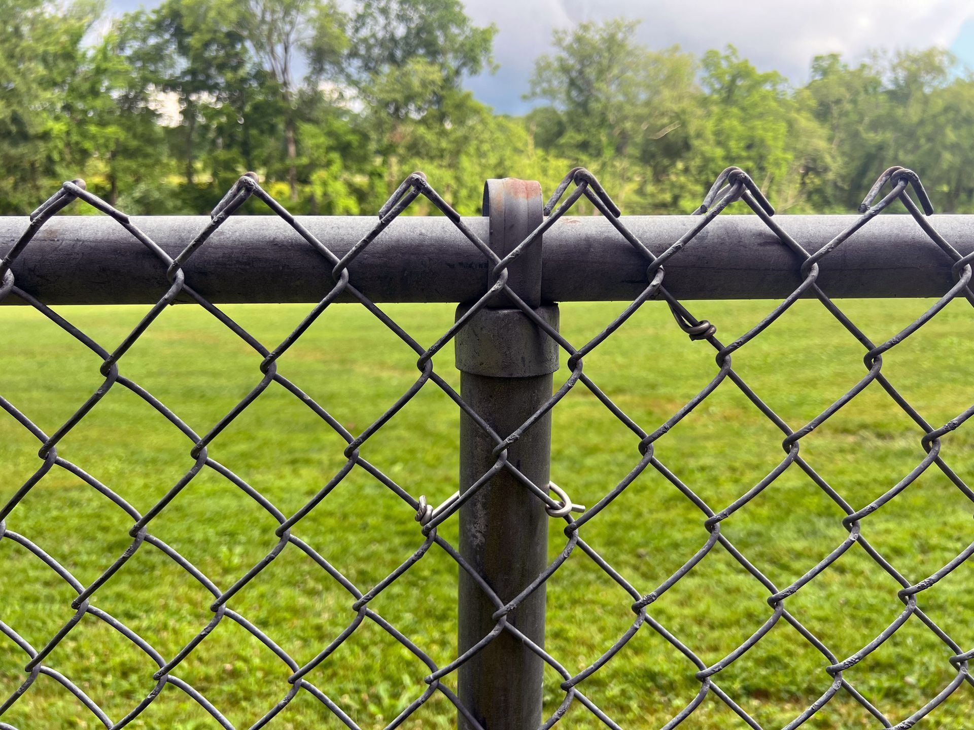 A close up of a chain link fence with a blurry background