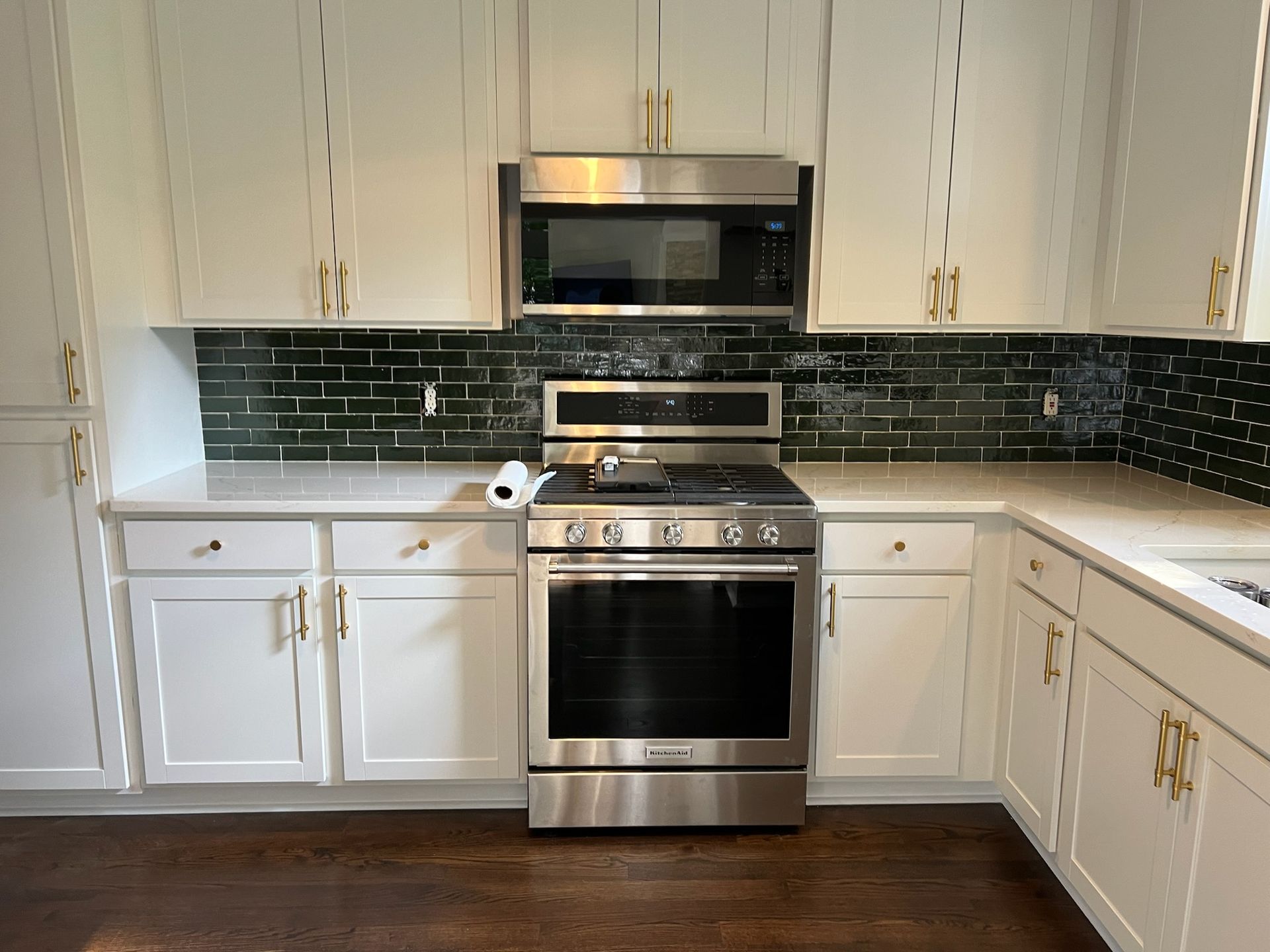 A kitchen with white cabinets and wooden stools