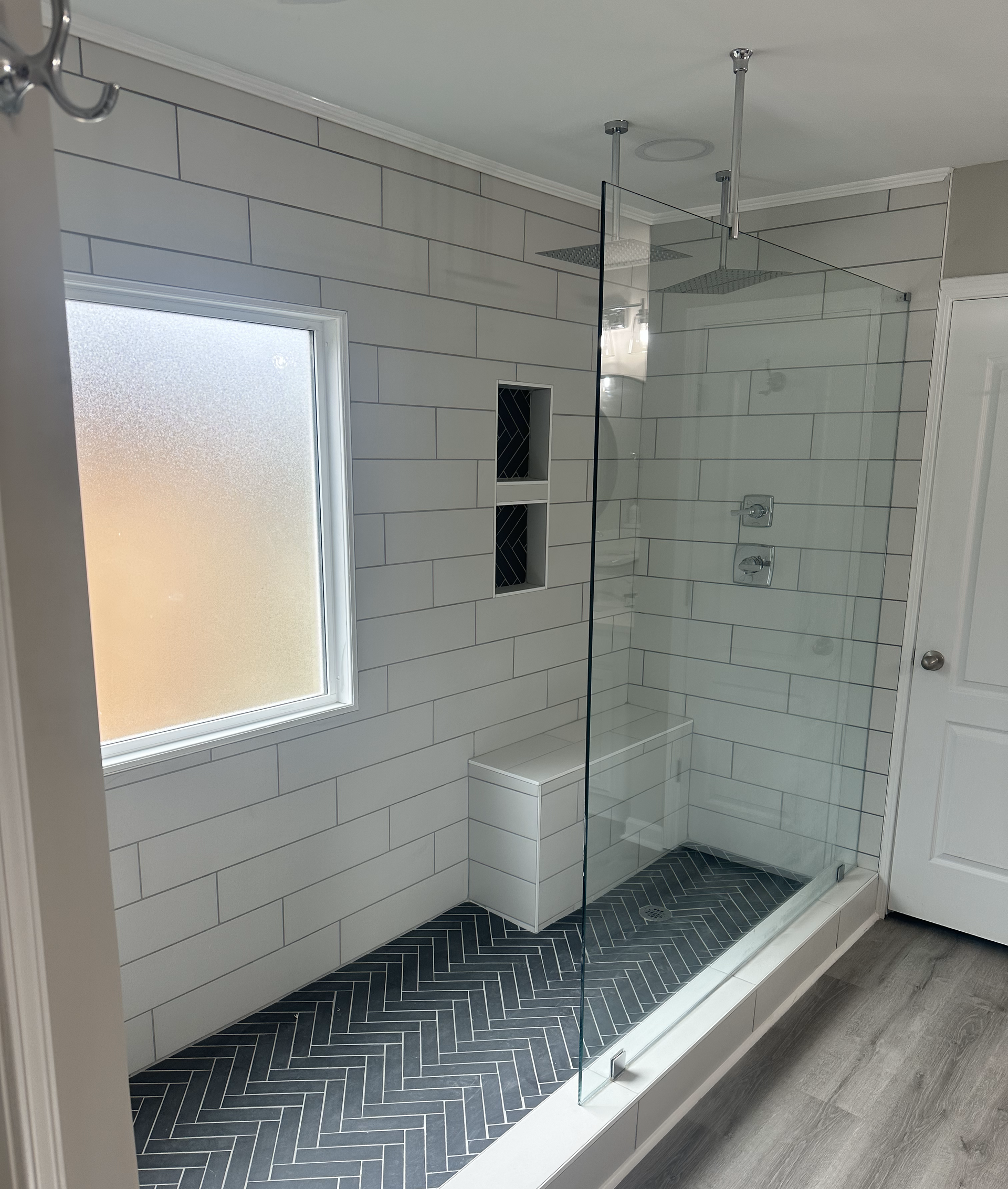 A bathroom with a walk in shower and a window