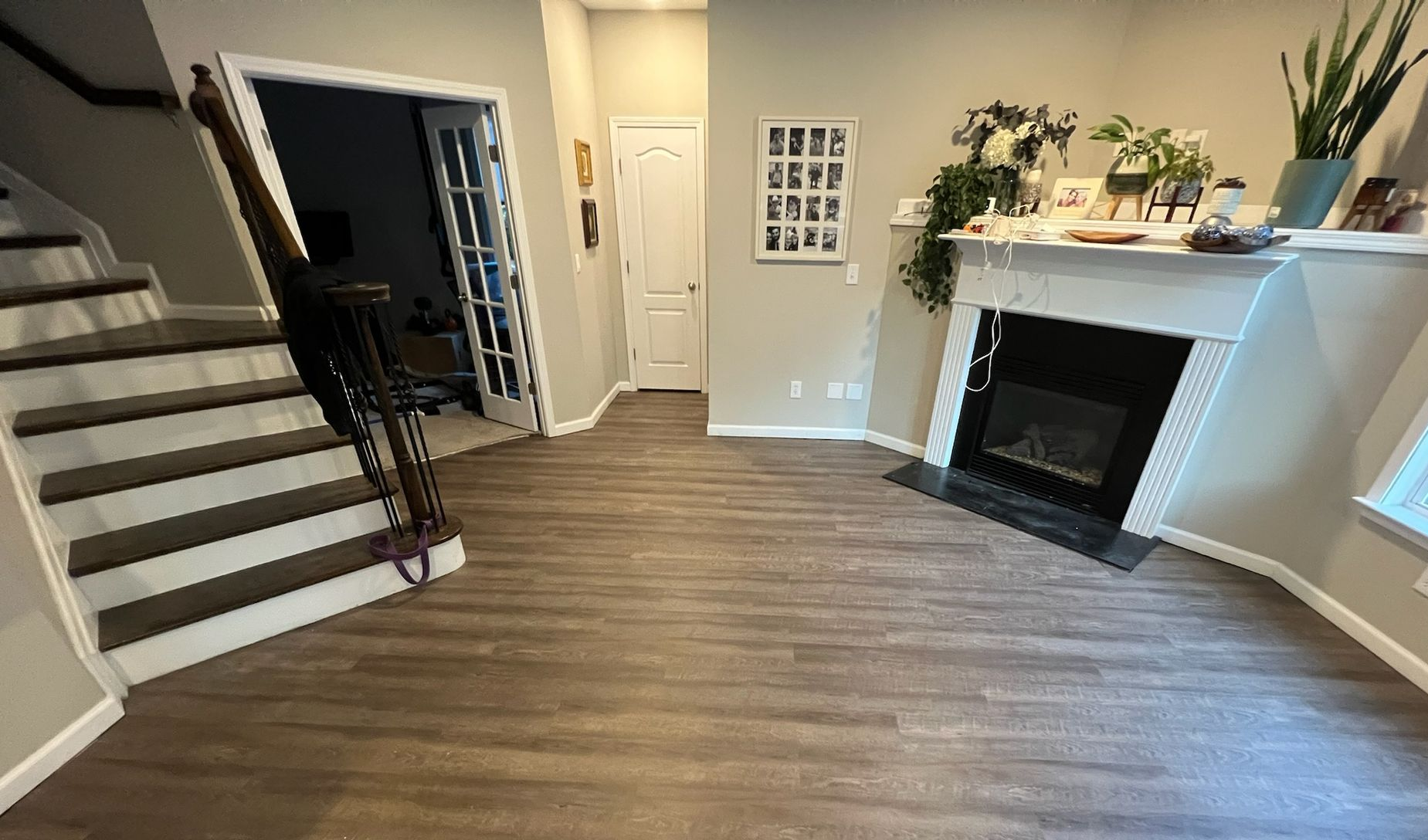 A living room with a couch , chairs , stairs and a pool table.