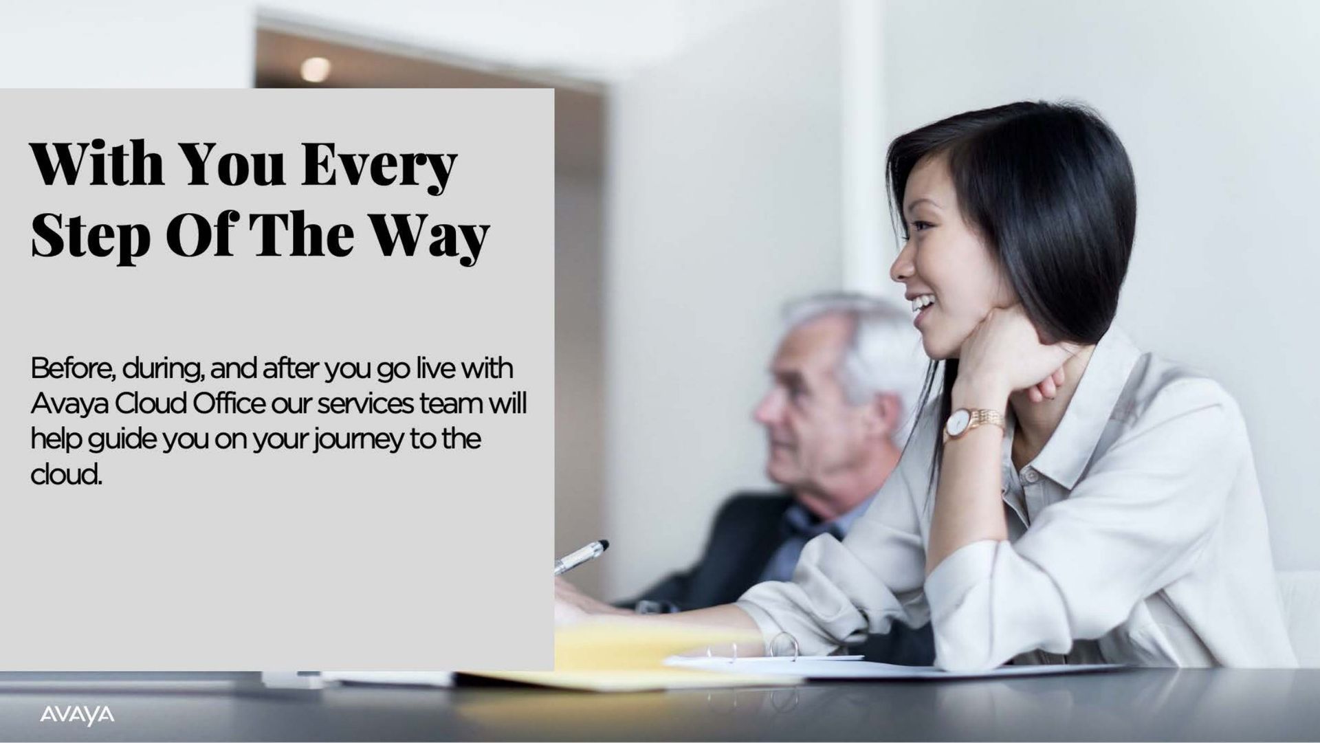 A man and a woman are sitting at a table with a sign that says with you every step of the way