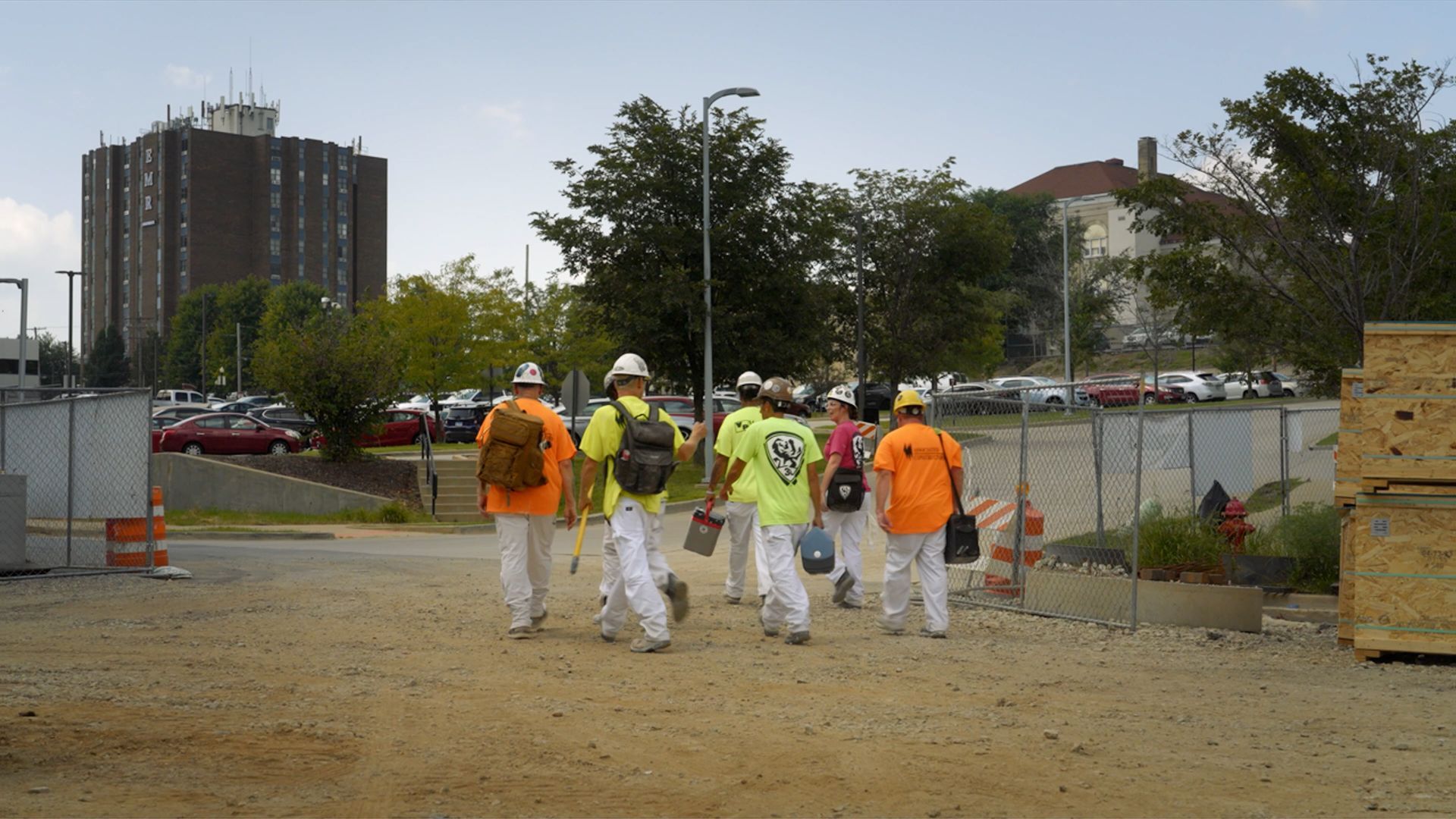A group of tradespeople walking across a job site at the end of a shift.