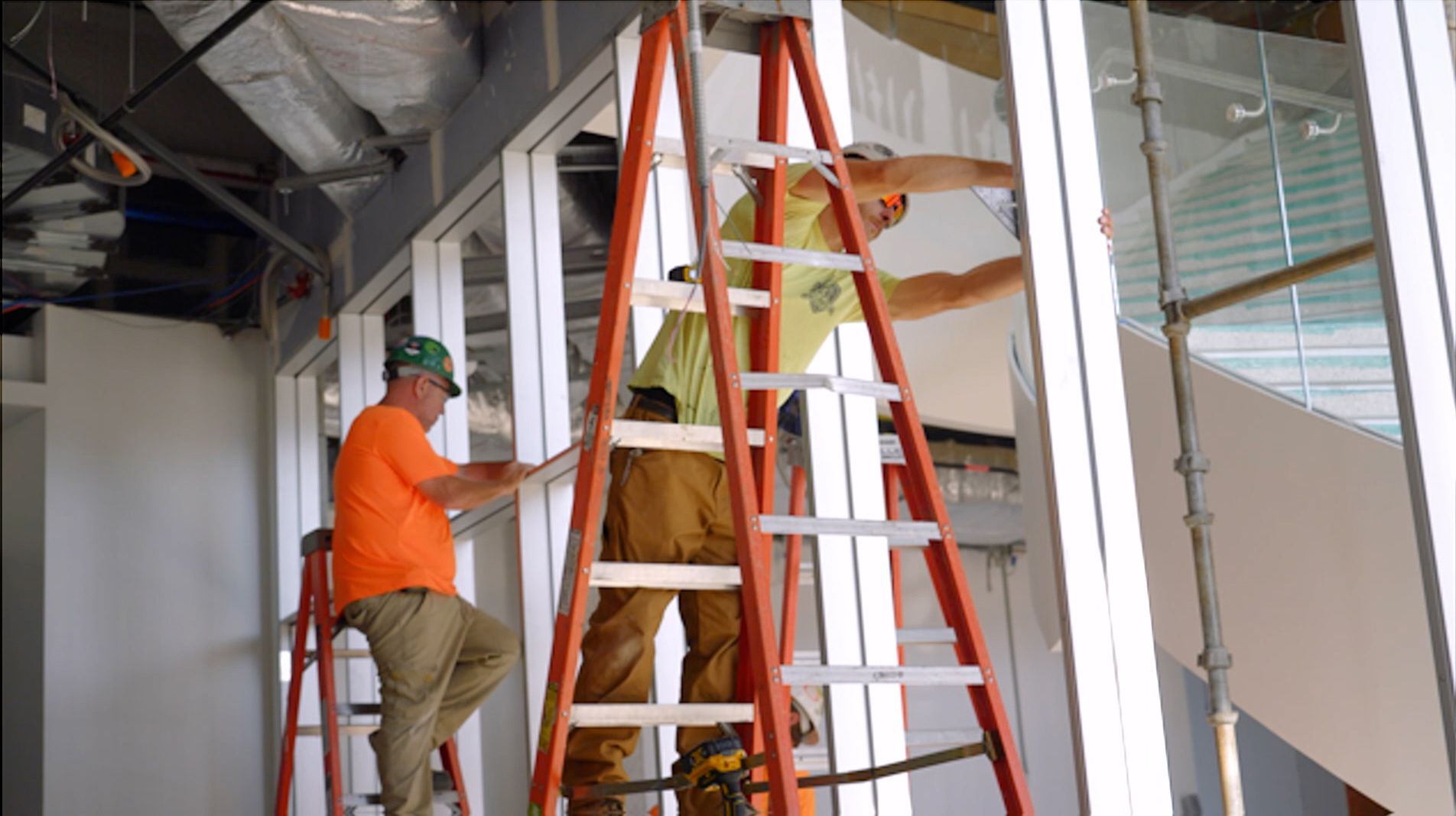 An NCIFTI apprentice working from a larder to install interior window framing within a new commercial construction project.