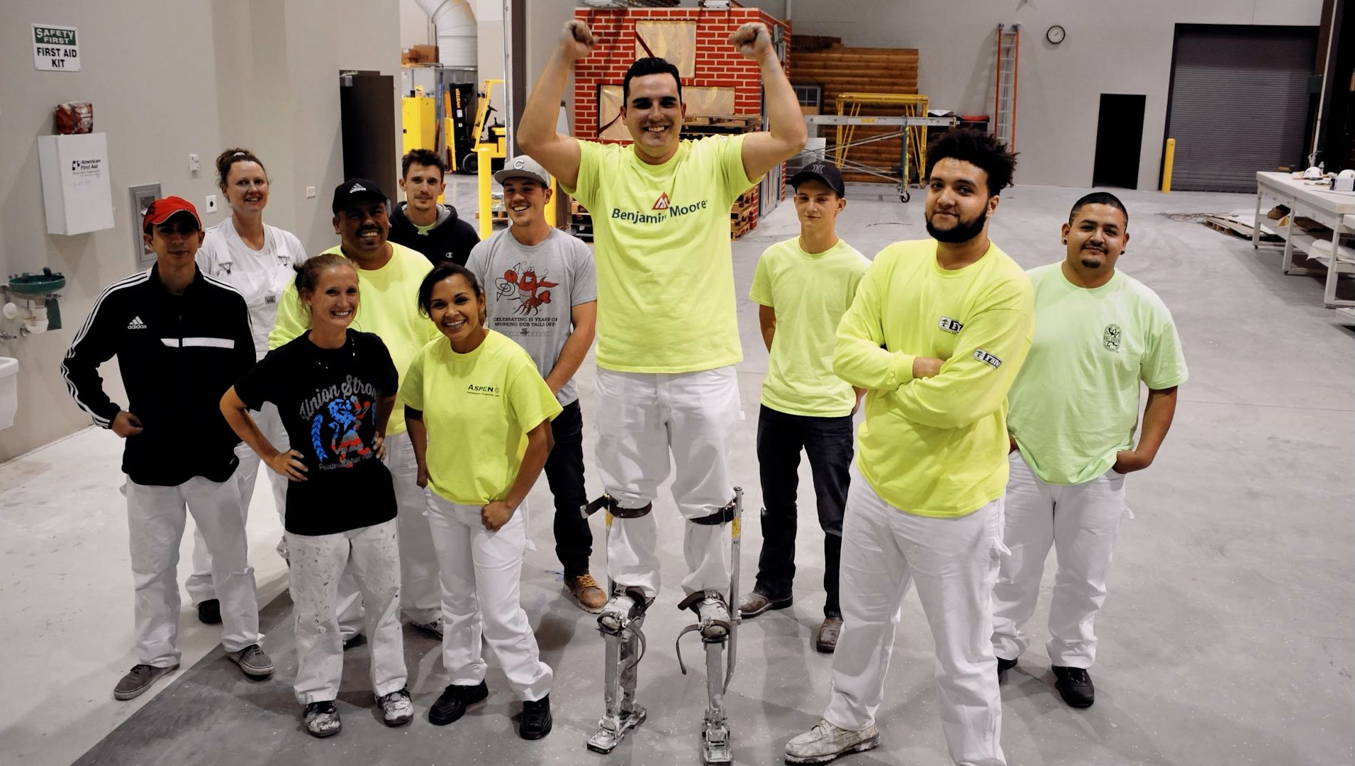 A group of NCIFTI students posing for a photo, white one student demonstrating the use of stilts. 