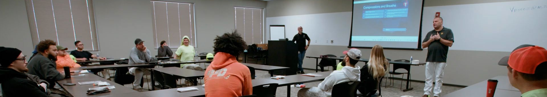An NCIFTI instructor lecturing a class of apprentices in a modern classroom setting.